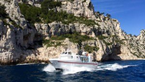 Statek wycieczkowy z turystami zwiedzającymi calanques obok Cassis